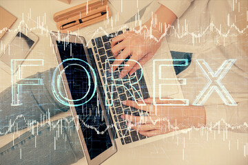 Double exposure of woman hands working on computer and forex graph hologram drawing. Top View. Financial analysis concept.