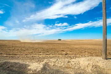 A spiral dirt or dust twister tornado moves through a dry field at a ranch site near Palouse Falls, Washington, USA