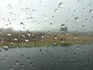 Gotas de lluvia en un cristal con fondo de un paisaje desenfocado