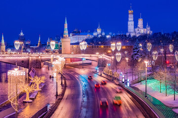 Moscow. Russia. Kremlin embankment on a winter evening. Moscow view from the drone. Cars ride on a winter road. New Year Kremlin Christmas decorations on lanterns and trees. Guide to Russia