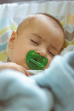 Hermoso bebe durmiendo arropado con chupon