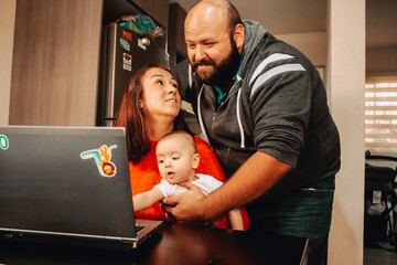 Joven Familia mexicana utilizando la computadora para planear un viaje