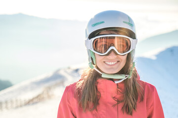 Closeup portrait of woman in helmet and mask with on ski resort
