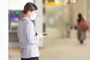 マスク姿で待ち合わせをする女性　OL
