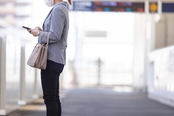 マスク姿で電車通勤をする女性