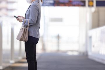 マスク姿で電車通勤をする女性