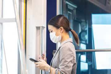 マスク姿で電車通勤をする女性