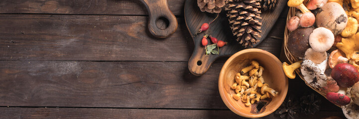 Autumn harvest of mushrooms on vintage rustic wooden background. Rustic kitchen table. Flat lay top, top view . Layout with free text space. Forest harvest concept. Banner.