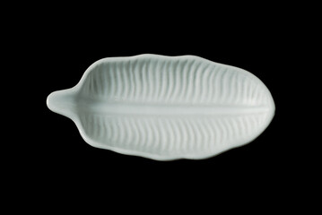 Small leaf shaped plate isolated on black background, top view image.