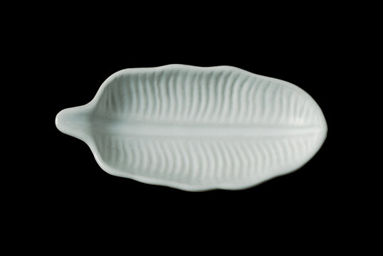 Small leaf shaped plate isolated on black background, top view image.