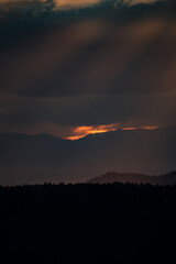 sunrays shining through clouds during sunset