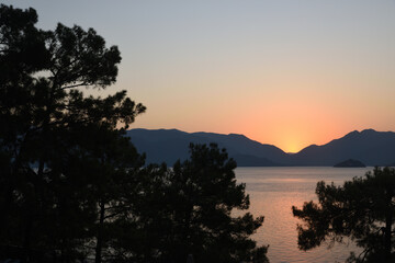 Sunset on the coast of the Aegean Sea - mountains, pines, sky, sea
