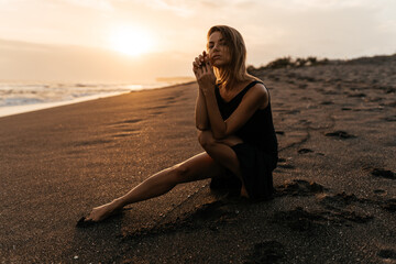 Fototapeta na wymiar woman on beach is enjoying serene ocean nature during travel holidays vacation outdoors sunset time
