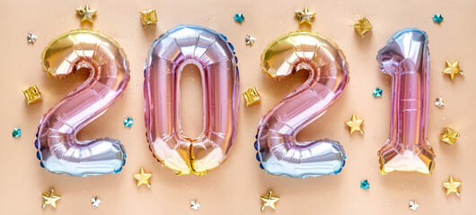 New year 2021 celebration. Foil balloons numeral 2021 and with Glitter Stars on  pastel background. Flat lay