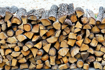 A pile of roughly chopped firewood stacked on top of each other.
