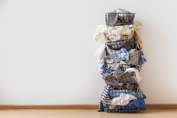One row of stacked metal laundry basket with full of clothing on white background.
