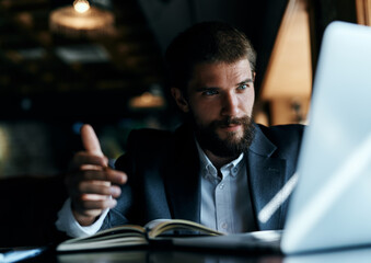 A business man in a suit is sitting in a cafe or with a laptop the work is an official