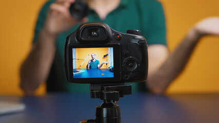 Artist testing camera lens while recording vlog episode in studio. Camera lens technology digital...