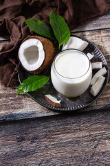 Diet and health nutrition concept. Vegan alternative nut milk from coconut on a kitchen table. Copy space.