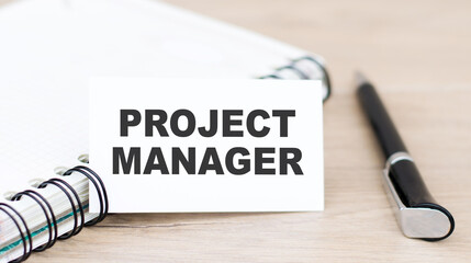 card with the inscription Project Manager near the notebook