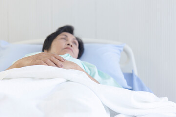 Asian concept elderly woman lying in bed and recuperate in the hospital.