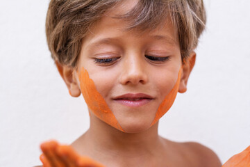 Portrait of cute child who is bathed in colored powders during Holi