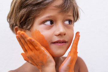 Portrait of cute child who is bathed in colored powders during Holi