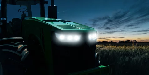 Photo sur Plexiglas Tracteur Agricultural tractor with headlights at night