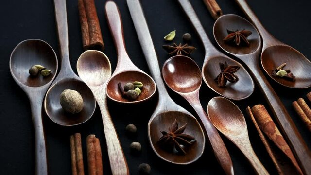 Colourful various herbs and spices for cooking on dark background.