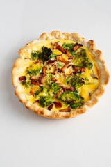 Whole broccoli and mushrooms pie on light surface