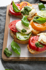 Caprese bruschetta with heirloom tomato on a wooden board