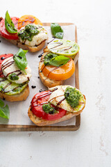 Caprese bruschetta with heirloom tomato on white table