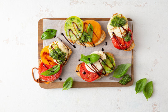 Overhead view of  Caprese bruschetta with heirloom tomato on white table
