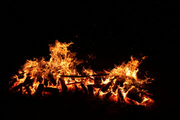 the flame of a burning campfire on a black background