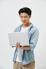 Young male student using laptop isolated on white background.
