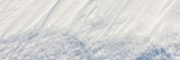 Beautiful winter background with snowy ground. Natural snow texture. Wind sculpted patterns on snow...
