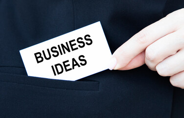 The businessman puts in his pocket a business card with the inscription BUSINESS IDEAS.