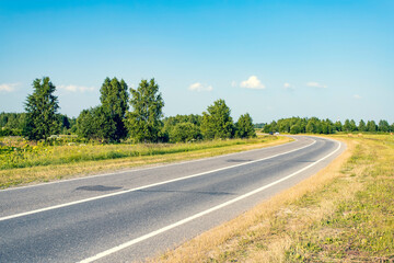 Asphalt road leading into the distance around the bend.