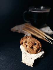 Cookies and hot Americano coffee in a transparent cup, black background.