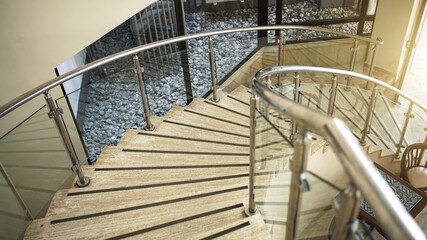 vntage spiral stone staircase with metal railing in hotel building