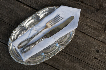 Vintage silverware, a small tray and cutlery on a wooden background