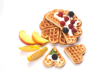 Waffles with berries and peaches isolated on white background