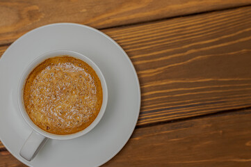 cup of espresso on a wooden countertop view from top