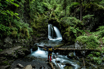 man in front of waterfall in the forest