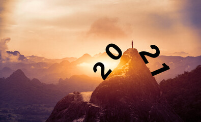 Peak Panoramic view on foggy mountains hills Successfully,man standing with 2020 years over the sun and through on the hill silhouette evening colorful sky. Succes . business and happy new year 2021