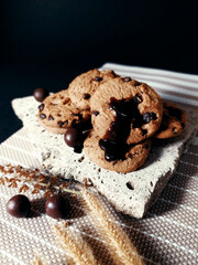 Chocolate chip cookies on rocks and elements Has a black background