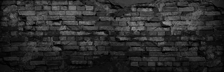 Black grunge background. Black old brick wall. Dark gray stone wall. Collapsing brickwork....