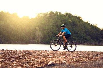 Mountain bikes cyclist cycling, silhouette Asian man athlete riding biking on rocky terrain trail, extreme sport wearing gear uniform, exciting freedom outdoor sunset nature healthy active lifestyle