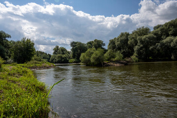 ruins of an old manor house among green trees against a blue sky