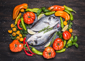 Obraz na płótnie Canvas Fish and various vegetables, healthy cooking dorado fish copy space dark background.